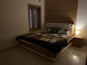 ein Schlafzimmer mit einem großen Bett und einem Fenster in der Unterkunft Baithak homestay in Lucknow