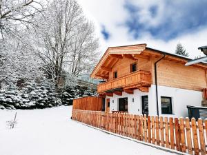 a wooden house with a fence in the snow at Almliesl WILD-728 in Oberau +4 photos