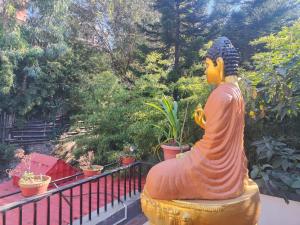 una statua di una donna seduta su un balcone di Nepal Blissful Nest And Family Home a Kathmandu