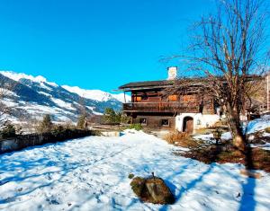 a log cabin in the snow with mountains in the background at Almliesl GAST-755 in Bad Hofgastein