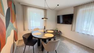 a dining room with a table and chairs and a tv at Gästehaus im Grünen in Pesendorf