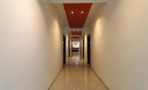ein leerer Flur mit einer roten Decke in einem Gebäude in der Unterkunft Suman Lodging near Mahalaxmi Temple, Kolhapur in Kolhapur