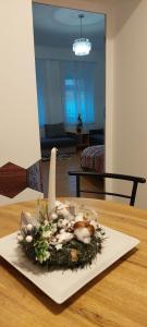 ein Blumenarrangement auf einem Teller auf einem Tisch in der Unterkunft Ánizs Apartmanház in Makó