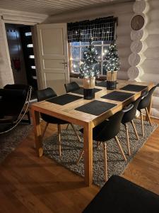a dining room table with a christmas tree on it at Harju-Hill Villa in Rovaniemi