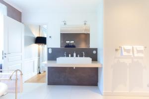 ein Badezimmer mit Waschbecken und Spiegel in der Unterkunft le clos des belvals in Vertus + 32 Fotos