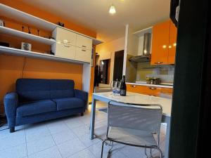 Bright apartment with pool near the sea في روزابينيتا: مطبخ به أريكة زرقاء وطاولة وكرسي