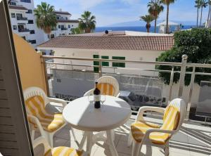 Un patio con una mesa y sillas en un balcón. en La Perla Ocean View, en Puerto de Santiago 18 fotos más