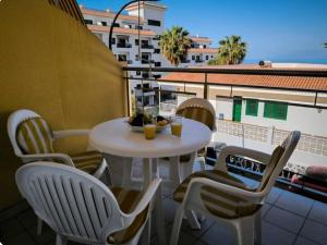 Una mesa y sillas en un balcón con vista. en La Perla Ocean View, en Puerto de Santiago