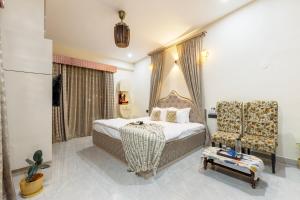 a hotel room with a bed and a chair at SaffronStays Shreevats in Bedla