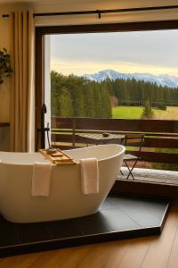 eine Badewanne vor einem Fenster mit Aussicht in der Unterkunft Alpentraum: Luxuswohnung mit atemberaubendem Blick in Buchenberg