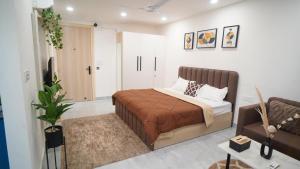 ein Schlafzimmer mit einem Bett und einer Couch in der Unterkunft Central suites with Terrace by Luxury Heights in Gurgaon + 3 Fotos