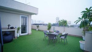 eine Terrasse mit Tisch und Stühlen auf einem Balkon in der Unterkunft Central suites with Terrace by Luxury Heights in Gurgaon