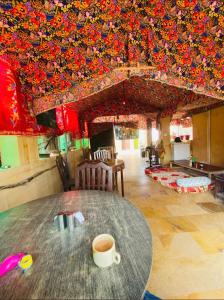 Hotel Al-raya Jaisalmer في جيلسامر: وجود كوب من القهوة على طاولة في الغرفة