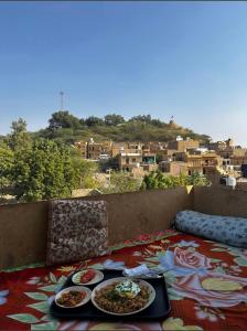 Hotel Al-raya Jaisalmer في جيلسامر: طاولة مع طبقين من الطعام على شرفة +20 صورة