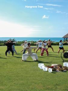 a group of people dancing in the grass at Yalong Bay Mangrove Tree Resort in Sanya +60 photos