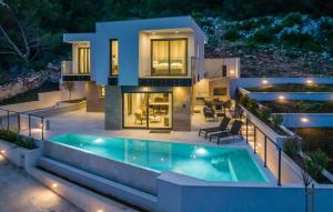 a house with a swimming pool at night at Luxurious Home In Dingac With Sauna in Gornji Dingač