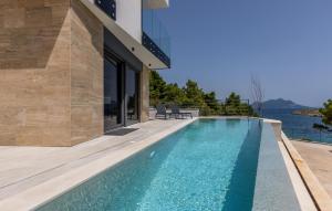 an infinity pool in a house with a view of the water at Luxurious Home In Dingac With Sauna in Gornji Dingač