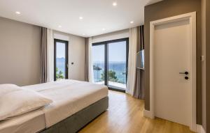 een slaapkamer met een groot bed en grote ramen bij Luxurious Home In Dingac With Sauna in Gornji Dingač