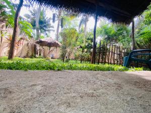 un patio con una sombrilla en un jardín en Bird garden Midigama, en Kumbalgama