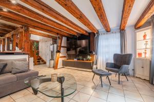 ein Wohnzimmer mit Sofa, Tisch und Stühlen in der Unterkunft La Maison des Colombages - Proche Strasbourg in Schiltigheim