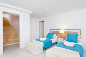 a white room with two beds and a table at Villa Paradise by Escape Home in Son Bou +41 photos