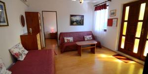 ein Wohnzimmer mit einer Couch und einem Sessel in der Unterkunft Arsenio in Veli Lošinj