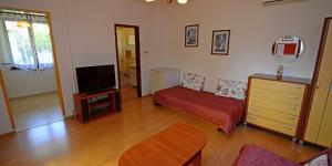 ein Wohnzimmer mit Sofa und Fernseher in der Unterkunft Arsenio in Veli Lošinj