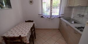 eine kleine Küche mit Tisch und Spüle in der Unterkunft Arsenio in Veli Lošinj + 37 Fotos