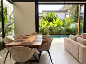 a dining room with a wooden table and chairs at Luxe & Privacy Orchard Villas Pasak 4BR in Laguna Phuket