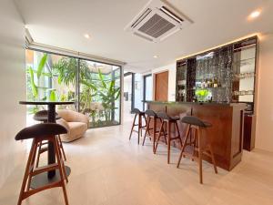 a bar with stools in a room with at Luxe & Privacy Orchard Villas Pasak 4BR in Laguna Phuket
