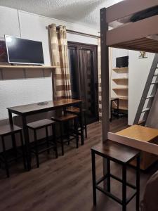 um quarto com uma mesa e cadeiras e um beliche em Un Isard au Pied des Pistes em Ax-les-Thermes