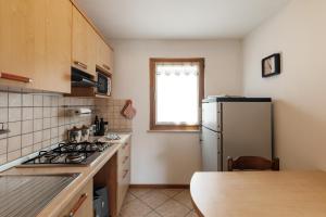 a kitchen with a refrigerator and a kitchen table at Dolomitihouse FRASSEN in Fiera di Primiero