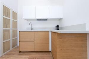 a kitchen with a sink and wooden cabinets at New Panoramic studio overlooking Monaco in Beausoleil +19 photos