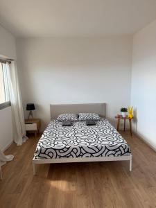 a bedroom with a bed with a black and white comforter at New Panoramic studio overlooking Monaco in Beausoleil