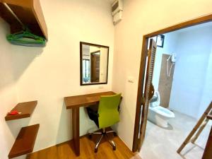 a bathroom with a desk and a green chair at Ingtara Lanta Valley in Ko Klang