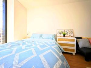 Box Hill Bright and Cozy Hotel Style One Bedroom Suite Kitchenette Ideal for Short Stays في بوكسهل: غرفة نوم بسرير ازرق وبيض وخزانة