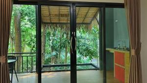 a room with glass doors and a balcony with trees at Ingtara Lanta Valley in Ko Klang
