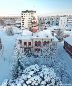 a building covered in snow in a city at Hostel Cafe Huvila in Oulu
