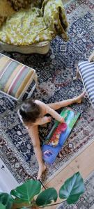 a doll sitting on a rug next to a bed at Hostel Cafe Huvila in Oulu +4 photos