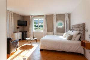 ein Schlafzimmer mit einem großen weißen Bett und einem Fenster in der Unterkunft le clos des belvals in Vertus