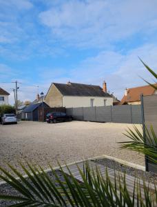 a house with a fence and cars parked in a driveway at L'Appart Indus et Parking Privé in Blois