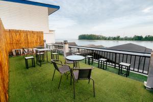 a balcony with tables and chairs and a view of the water at Lanta Chaolay in Ko Lanta