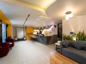 ジャイプールにあるムスタッシュ ホステル ジャイプールのソファとバーのあるリビングルーム