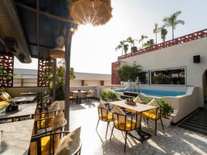 a restaurant with tables and chairs and a pool at Moustache Jaipur,Hostel & Rooftop Bar in Jaipur +76 photos