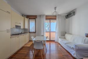 Una sala de estar con un sofá blanco y una mesa. en Bontempi House, en Pioltello