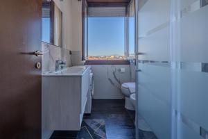 baño con lavabo y aseo con ventana en Bontempi House, en Pioltello 24 fotos más