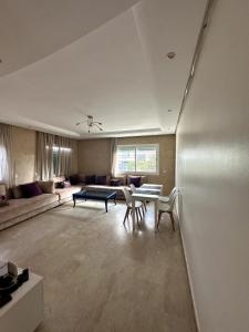 een grote woonkamer met een tafel en stoelen bij La Perle Aïn Diab Beachfront in Casablanca