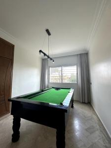 een pooltafel in een kamer met een groene doek bij La Perle Aïn Diab Beachfront in Casablanca +6 foto's