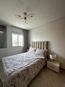 een slaapkamer met een groot bed en een raam bij La Perle Aïn Diab Beachfront in Casablanca