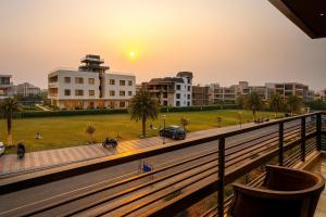 a view of a city at sunset from a balcony at Pearl Grand Boutique Cottage In Omaxe Anandam Vrindavan -# Premium AC Rooms With Balcony # Big Parking # Lift # Garden # Peaceful Area # Near Prem Mandir # Property Of The Year # Most Awarded in Vrindāvan
